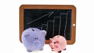 Chalkboard with an ascending bar chart and arrow in front of two piggy banks (purple and pink). But concise: Piggy banks with rising chart on chalkboard.
