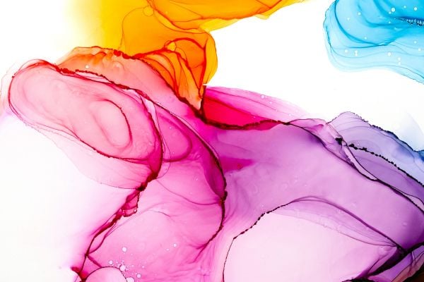Abstract splash of vibrant pink, purple, orange, and blue ink flowing in water, forming swirling shapes.
