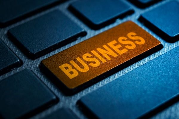 Gold key labeled 'BUSINESS' on a blue keyboard, symbolizing a business focus in a tech context.