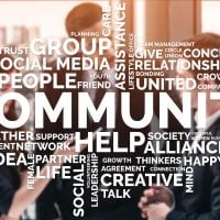 Group of professionals in a meeting with a large word-cloud emphasizing community, collaboration, and helping.