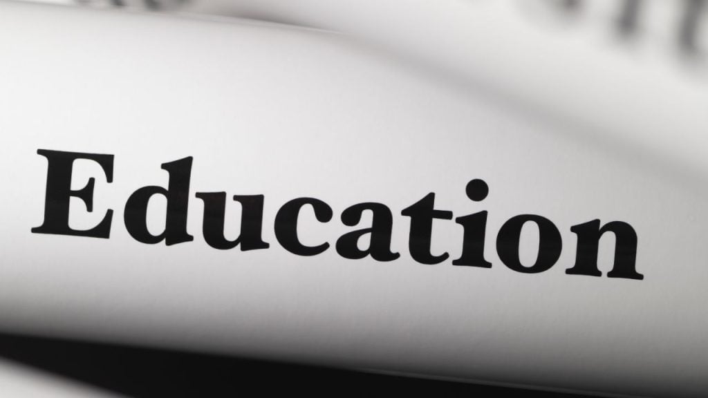 Close-up of the word 'Education' printed in bold on a curved white surface.