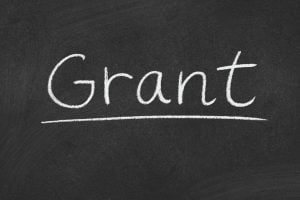 Chalkboard with the word 'Grant' written in white chalk, underlined.