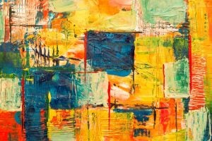 Abstract acrylic painting with bold overlapping blocks of orange, yellow, blue and green and textured brushstrokes.