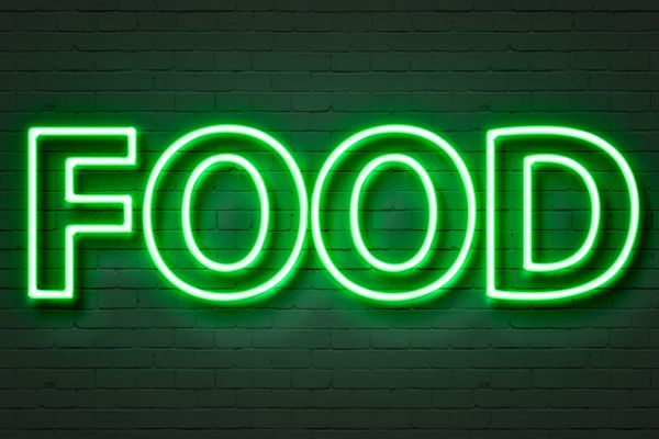 Bright green neon sign spelling 'FOOD' on a dark brick wall.