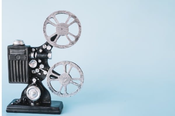Marine Conservation 18 - fundsforNGOs Vintage film projector with two metal reels on a black base against a light blue background, ready to project film.
