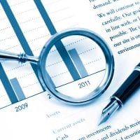 Research Projects - fundsforNGOs Bar chart of financial data from 2008–2011 with a magnifying glass over the 2011 bar and a pen nearby.