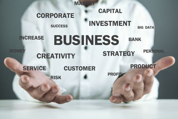 business 2 - fundsforNGOs Hands cupped as if presenting floating business terms (BUSINESS center, INVESTMENT, STRATEGY, CREATIVITY, SUCCESS) to convey business ideas and services