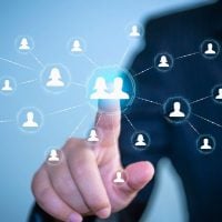 business 7 - fundsforNGOs Hand touching a glowing central avatar in a network of interconnected user icons, symbolizing social or professional networking