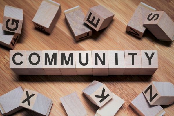 community 5 - fundsforNGOs Wooden letter blocks spell COMMUNITY on a wood surface with scattered letters around, illustrating togetherness.