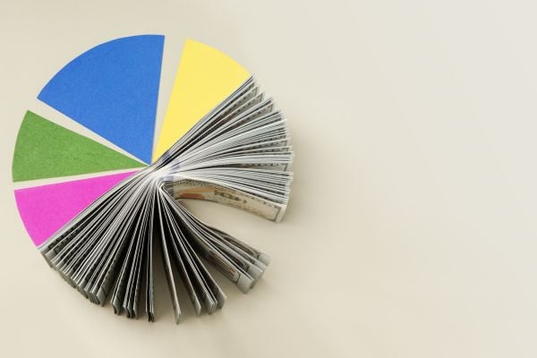 Opened magazine pages fanned into a colorful pie chart with blue, yellow, green, and pink segments on a light background.