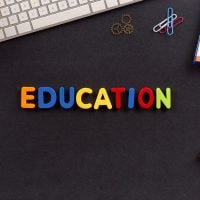 education 1 - fundsforNGOs Colorful letters spelling EDUCATION on a dark desk with keyboard, notebook, paperclips, and markers nearby