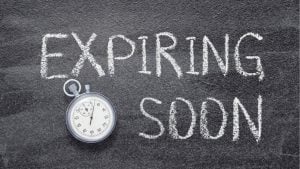 Chalkboard with 'EXPIRING SOON' written in chalk beside a stopwatch.