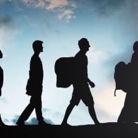 education and sports for children - fundsforNGOs Silhouettes of five students walking in a line with backpacks against a cloudy sky at sunset/date line horizon.