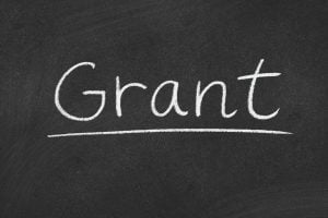 The word 'Grant' written in white chalk on a blackboard with an underline.