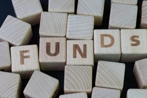 Wooden blocks arranged to spell FUNDS on a dark surface.