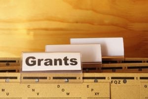 Label reading 'Grants' on a filing cabinet drawer with blank index tabs nearby.