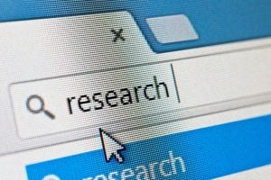 Web browser search field with a magnifying glass icon and the word 'research', with the cursor pointing at the field.