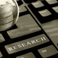 research 5 - fundsforNGOs Keyboard with a prominent 'RESEARCH' key and a globe beside it, symbolizing online or global research.