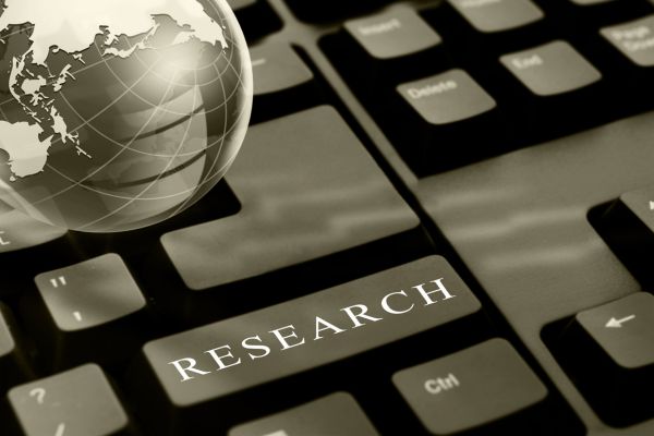 research 5 - fundsforNGOs Keyboard with a prominent 'RESEARCH' key and a globe beside it, symbolizing online or global research.